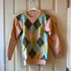 woman’s pink argyle sweater